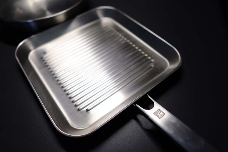 A photo of a stainless steel griddle pan with raised ridges